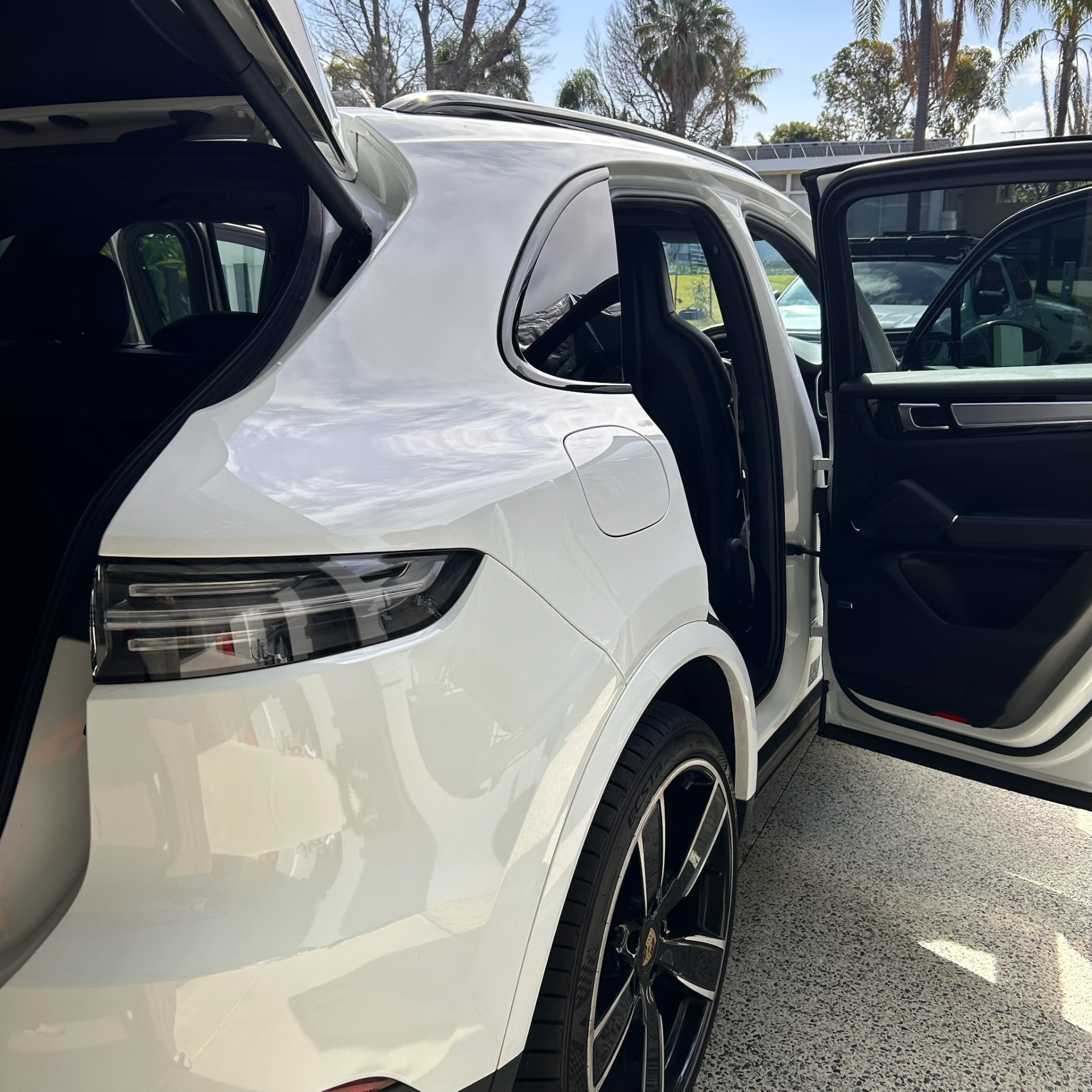 White Porsche Cayenne with doors and boot open mid full detail