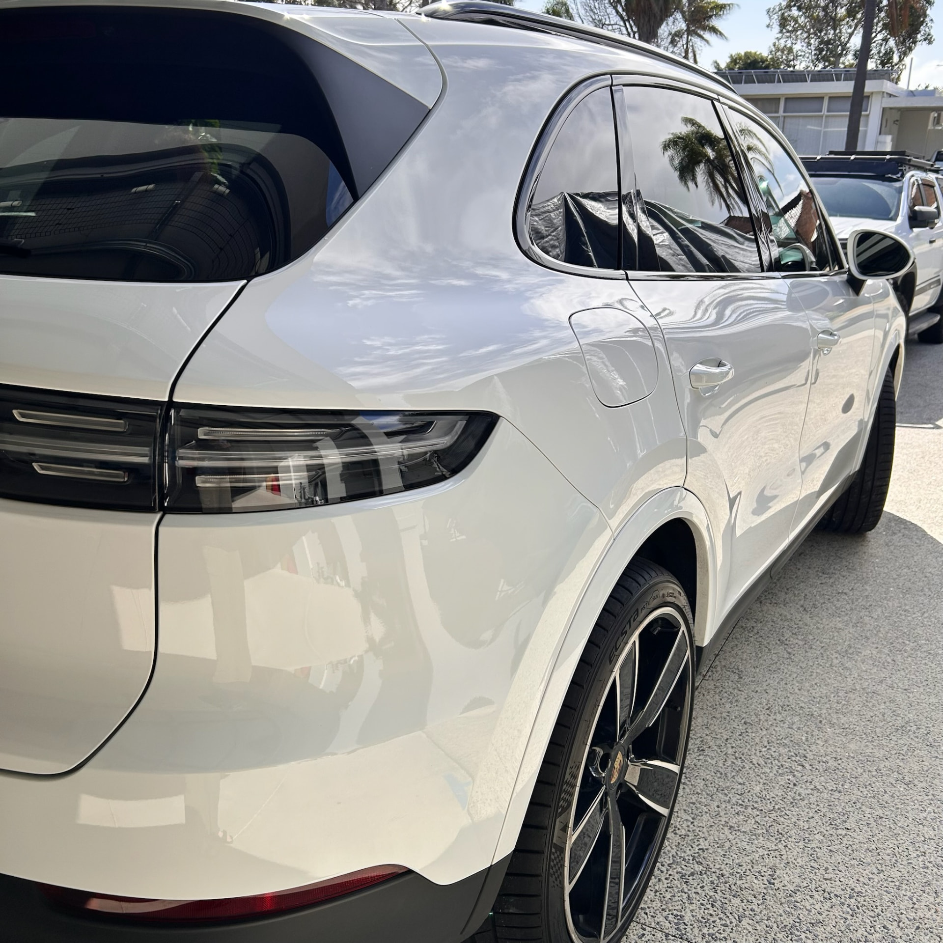 Freshly detailed white Porsche Cayenne with mirror-gloss paintwork in Perth sunlight